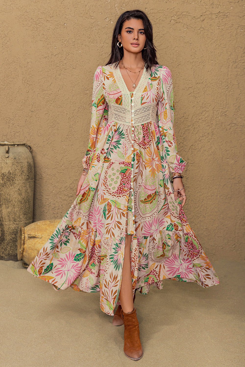 Long sleeve maxi dress with vibrant floral abstract print in green, orange, pink, and burgundy on a cream background, featuring buttons from mid-chest to mid-skirt and lace detailing around the neckline and under the bust.