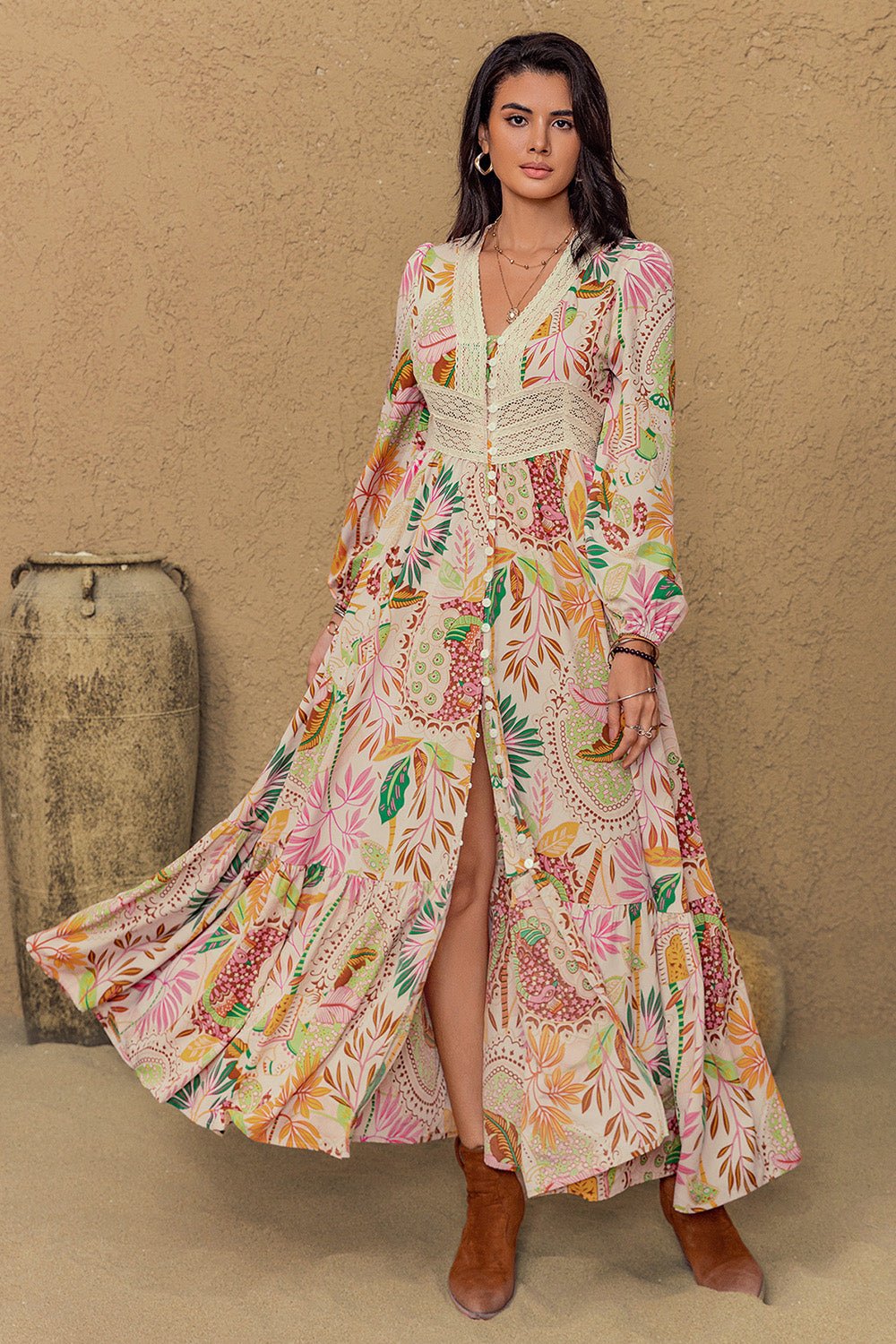 Long sleeve maxi dress with vibrant floral abstract print in green, orange, pink, and burgundy on a cream background, featuring buttons from mid-chest to mid-skirt and lace detailing around the neckline and under the bust.