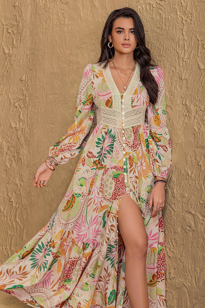 Long sleeve maxi dress with vibrant floral abstract print in green, orange, pink, and burgundy on a cream background, featuring buttons from mid-chest to mid-skirt and lace detailing around the neckline and under the bust.